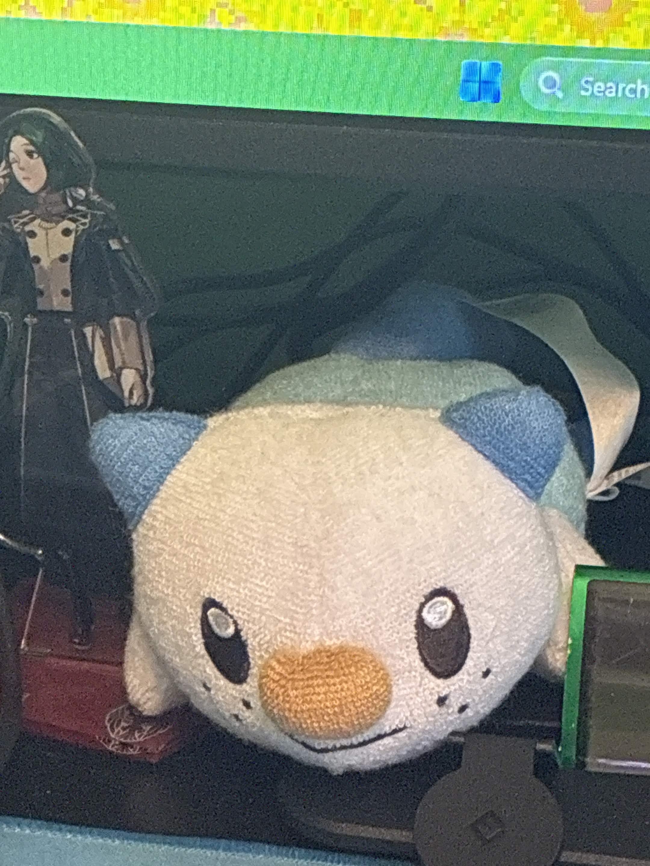 A small portion under my monitor featuring a plush of the Pokemon, Oshawott.